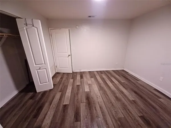 a view of a room with wooden floor and electronic appliances