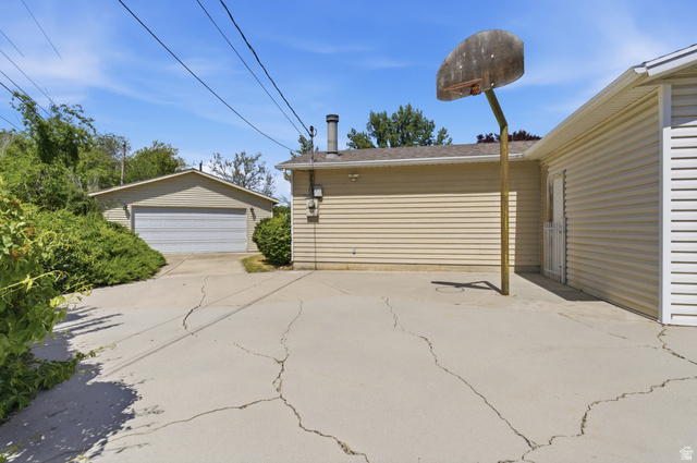 148 Tennyson Avenue Sandy, UT 84070 - Photo 45 of 55 Detached two-car garage with a roll-up door, accompanied by a spacious concrete driveway