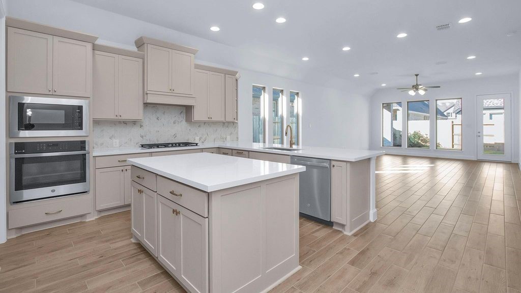 42560 Rustico Road Magnolia, TX 77354 - Photo 3 of 22 a kitchen with a sink stove and cabinets