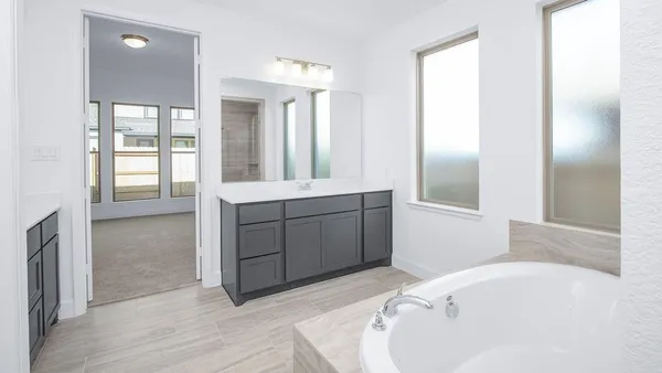 a bathroom with a tub sink and mirror