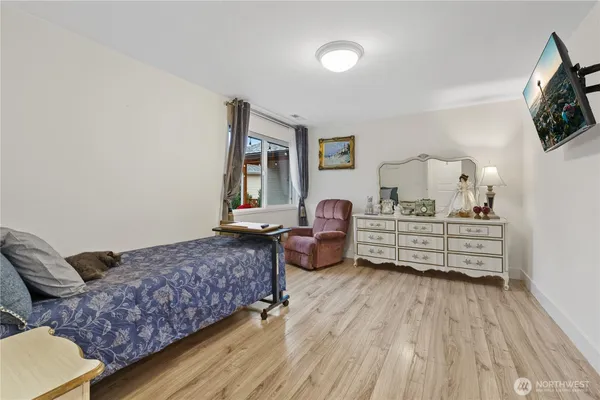 a bedroom with a bed and wooden floor