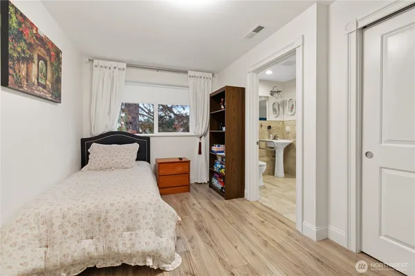 a large bedroom with a bed and a wooden floor