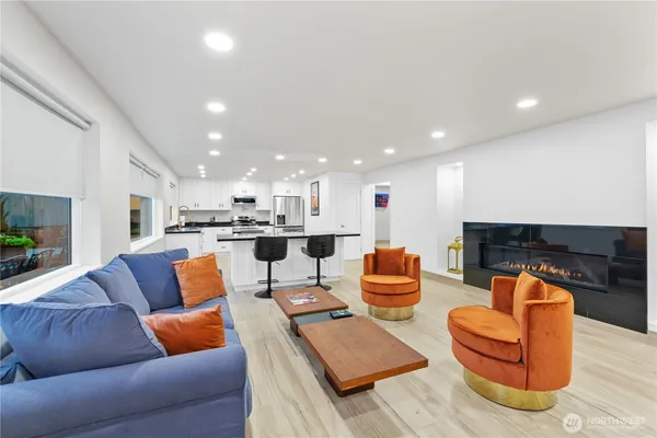 a living room with furniture kitchen view and a fireplace