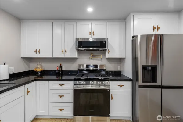a kitchen with stainless steel appliances granite countertop a stove a refrigerator and a granite counter tops