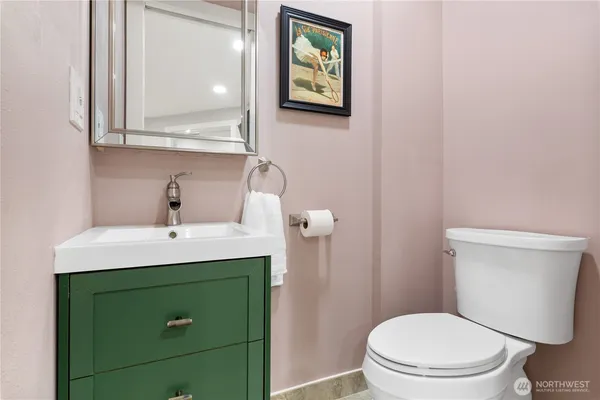 a bathroom with a toilet sink and mirror