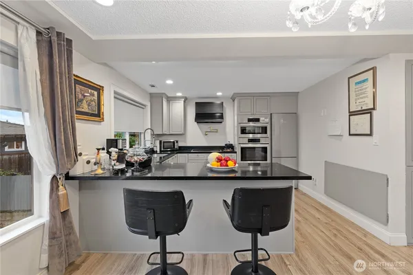 a kitchen with stainless steel appliances granite countertop a sink and a refrigerator