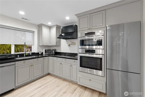 a kitchen with granite countertop white cabinets and stainless steel appliances