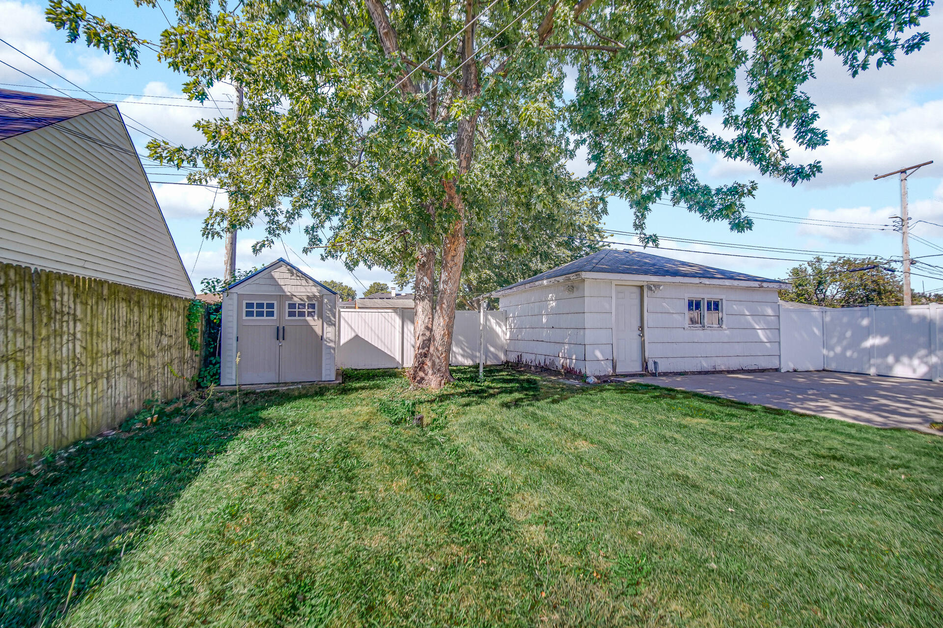 4004 Johnson Avenue Hammond, IN 46327 - Photo 17 of 18 a view of a backyard with wooden fence and a large tree