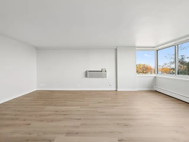 a view of a kitchen with wooden floor and a window
