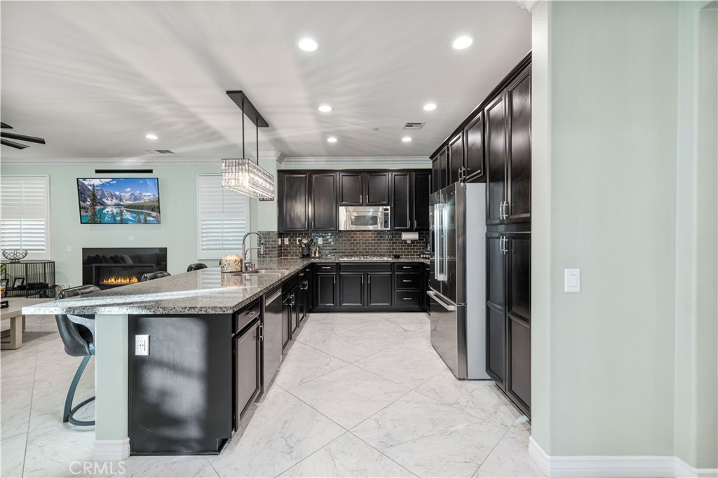 28537 Vista Del Rio Drive Valencia, CA 91354 - Photo 11 of 53 a kitchen with stainless steel appliances kitchen island granite countertop a refrigerator a sink and a stove