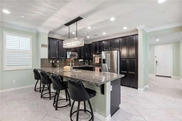 a kitchen with stainless steel appliances granite countertop counter space a sink refrigerator and cabinets