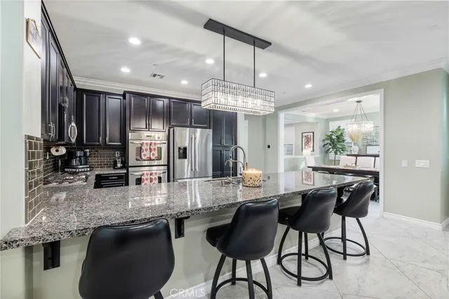 a large kitchen with granite countertop stainless steel appliances and a sink