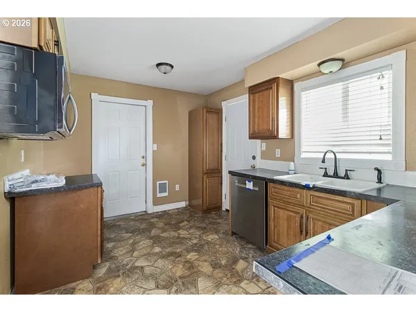 a kitchen with granite countertop a sink and a refrigerator