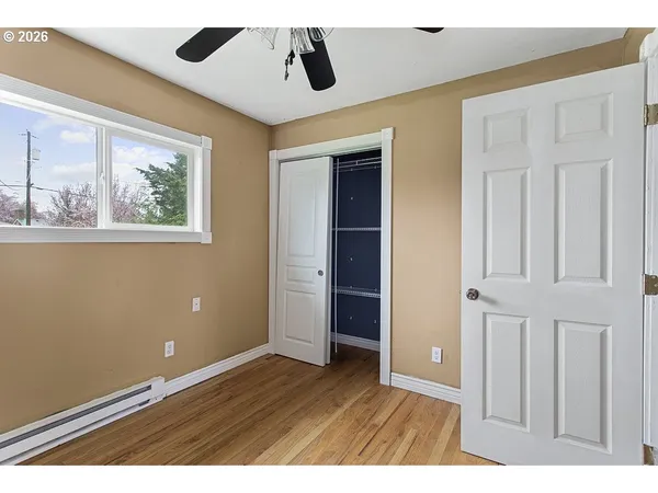 view of an empty room with wooden floor and a window