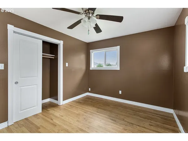 a view of an empty room with wooden floor