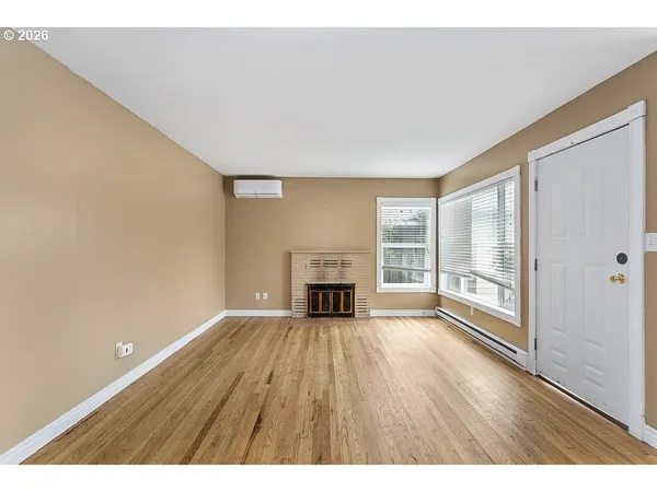 a view of an empty room with a window and fireplace