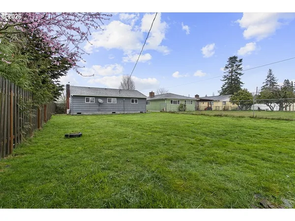 a view of a big yard with a house in the background