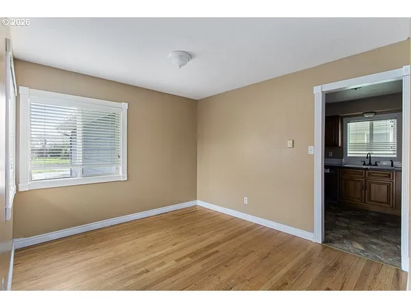 a view of an empty room with a kitchen and a window
