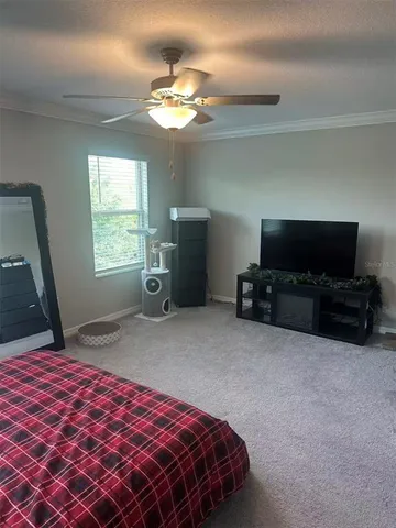 an empty room with windows and chandelier fan