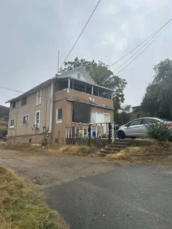a view of a big house with a big yard and large trees