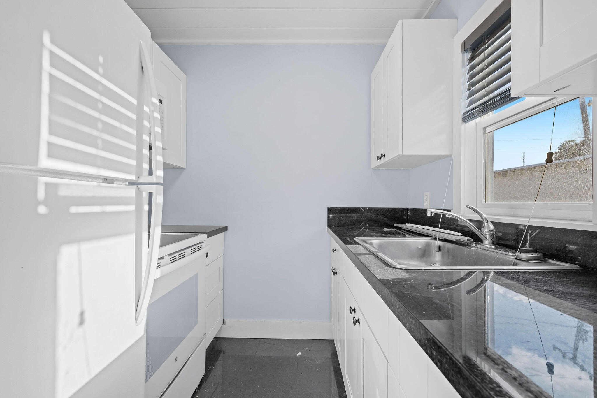 840 Almeria Road, Unit 2 West Palm Beach, FL 33405 - Photo 11 of 15 a kitchen with a sink stove and refrigerator