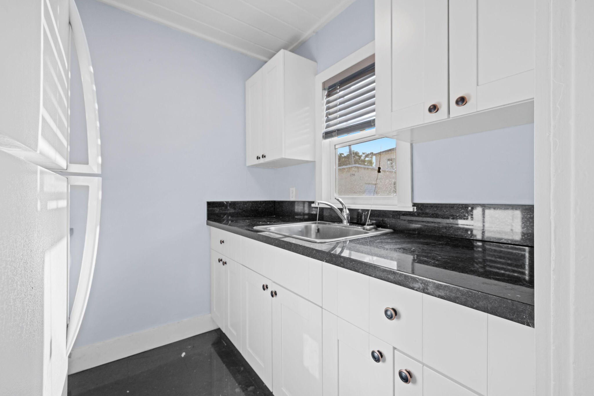 840 Almeria Road, Unit 2 West Palm Beach, FL 33405 - Photo 10 of 15 a kitchen with granite countertop white cabinets and a sink