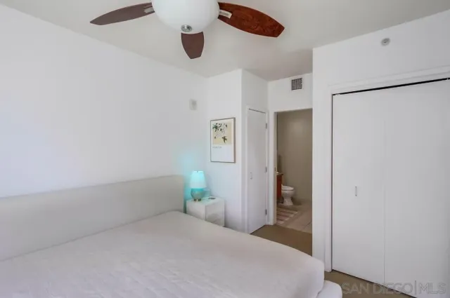 a bedroom with a bed and a refrigerator