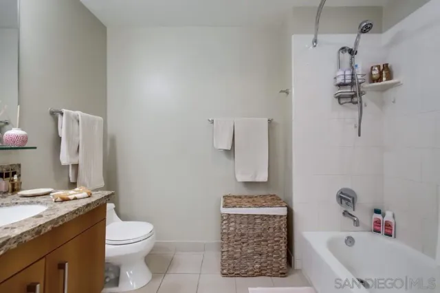 a bathroom with a granite countertop sink a toilet and a mirror