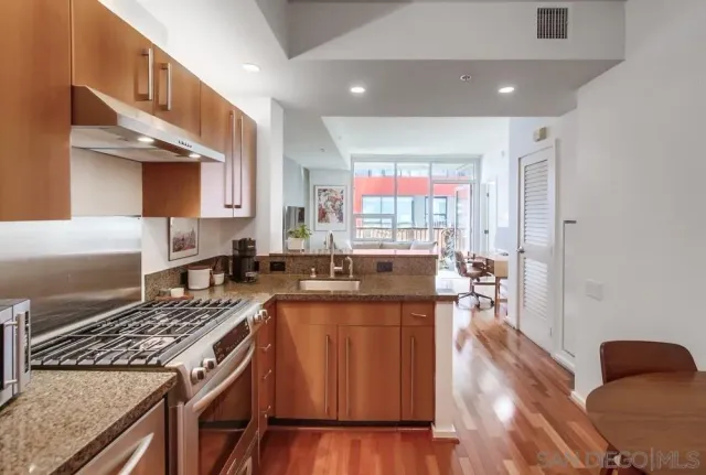 a kitchen with stainless steel appliances granite countertop a stove a sink dishwasher and a refrigerator