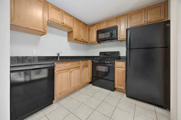a kitchen with a refrigerator sink and cabinets