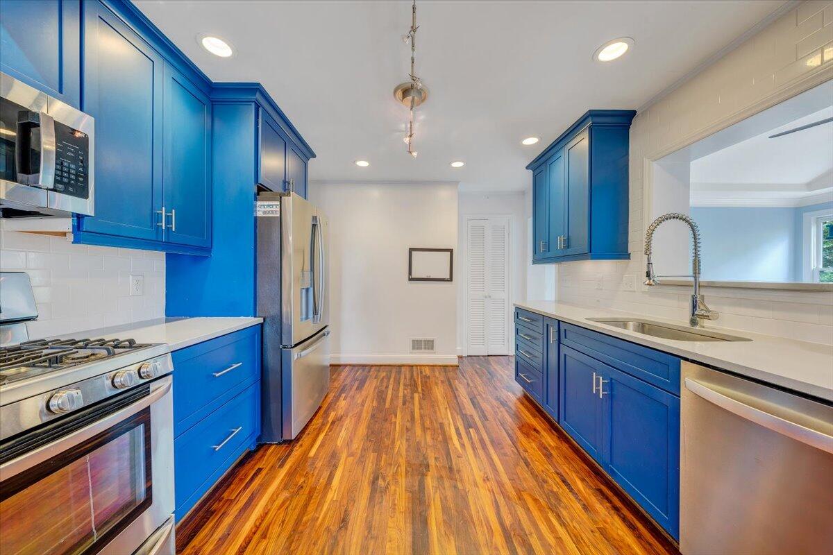 3135 West Ridge Road Southwest Roanoke, VA 24014 - Photo 14 of 50 a kitchen with wooden floors and stainless steel appliances