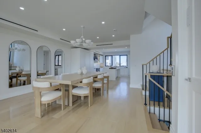 a dining room with wooden floor and white walls