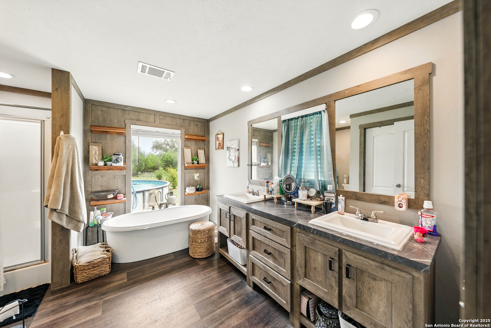 238 Las Palomas Drive Lytle, TX 78052 - Photo 11 of 25 a bathroom with double vanity sinks a large mirror next to a window
