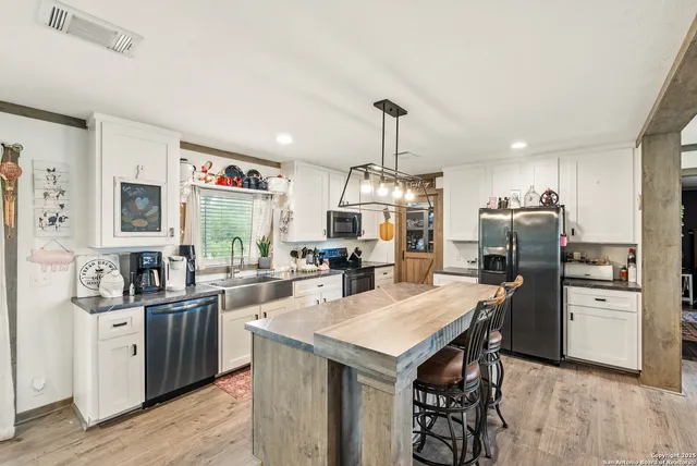 a view of a dining room and livingroom with furniture wooden floor a chandelier