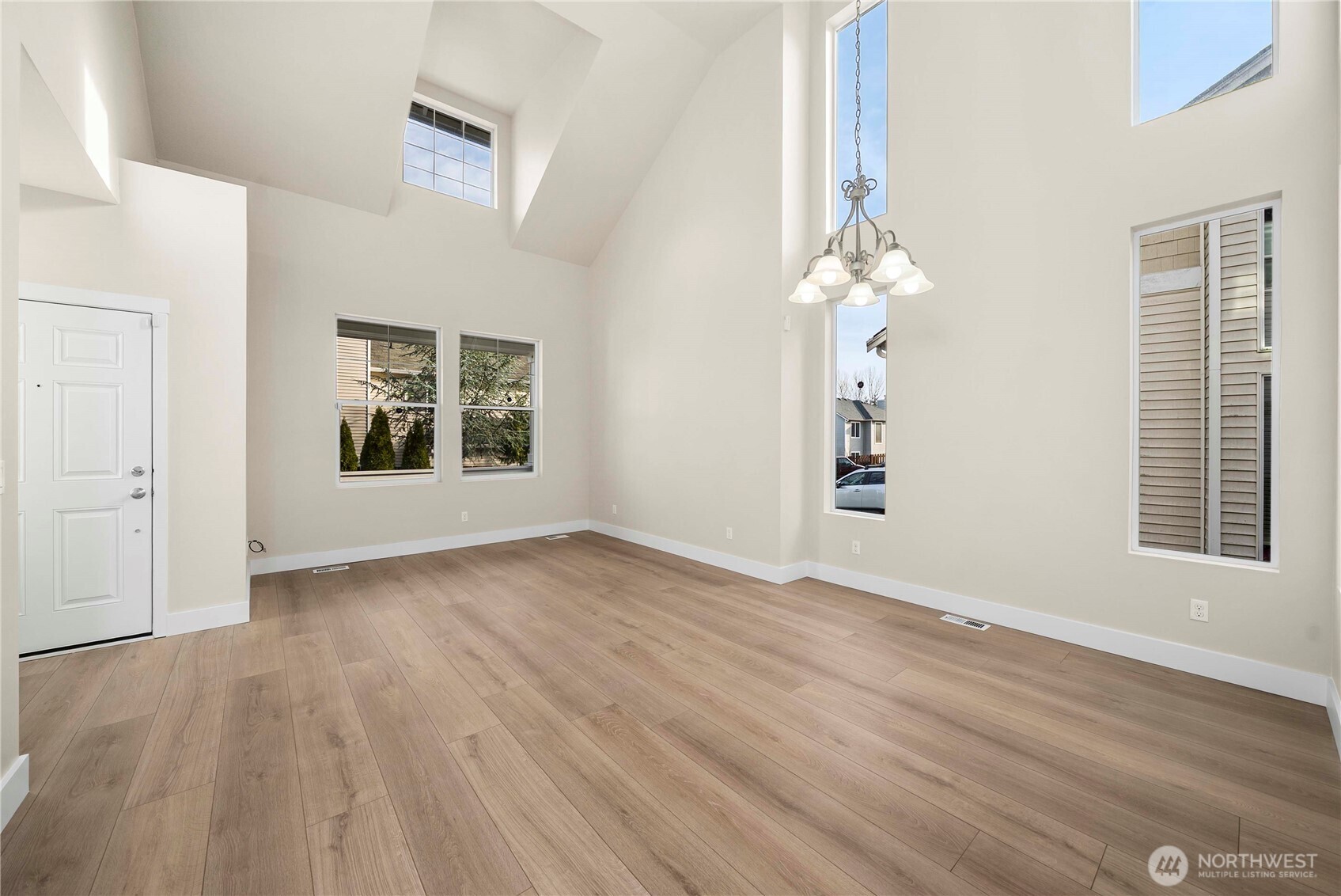 4125 South 220th Place, Unit 26 Kent, WA 98032 - Photo 4 of 39 an empty room with wooden floor chandelier and windows