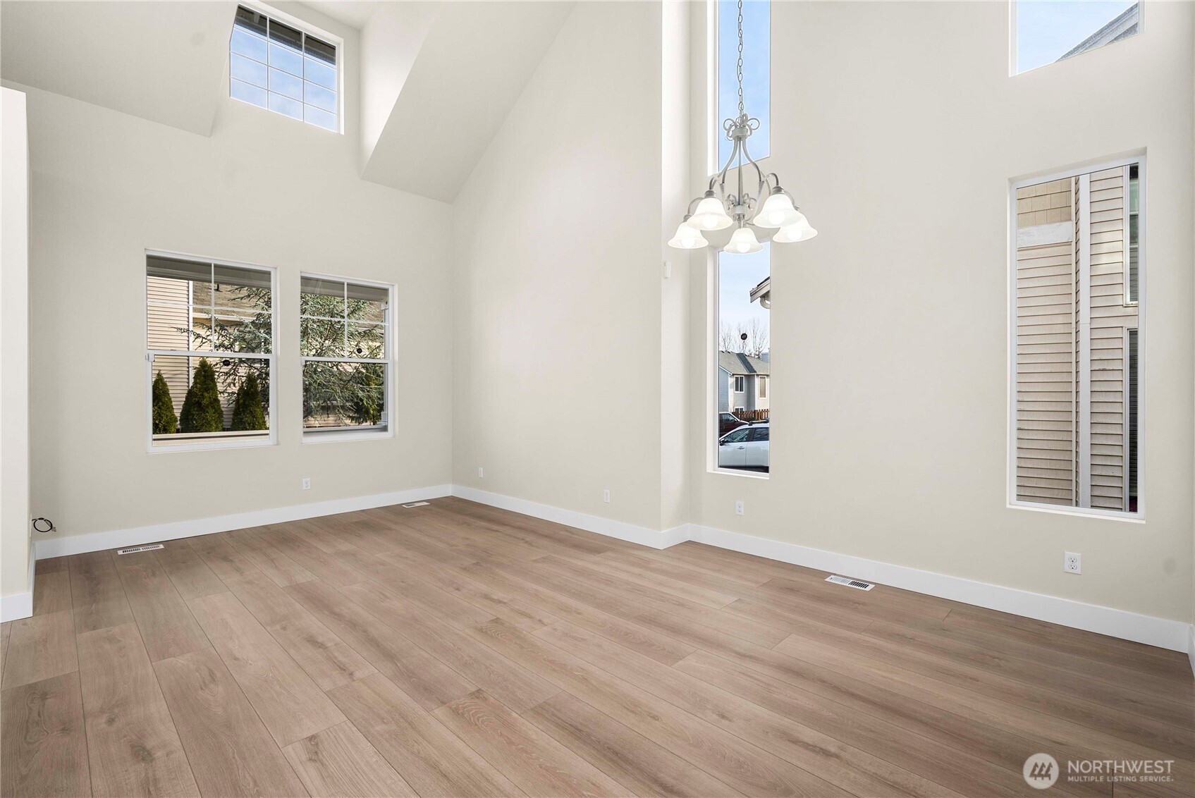 4125 South 220th Place, Unit 26 Kent, WA 98032 - Photo 6 of 39 an empty room with wooden floor chandelier and windows