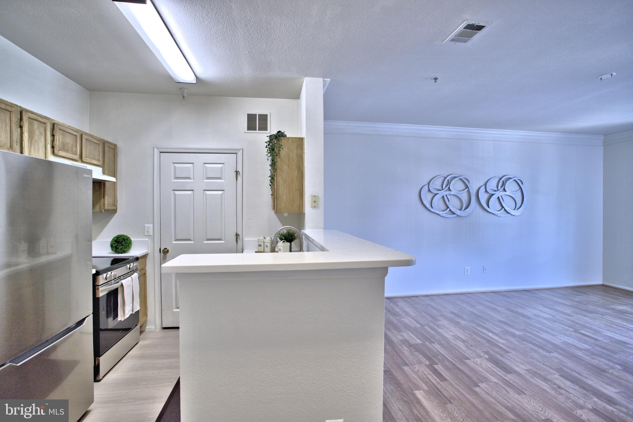 1570 Spring Gate Dr., Unit 7215 McLean, VA 22102 - Photo 5 of 30 a room with stainless steel appliances granite countertop a sink and a refrigerator
