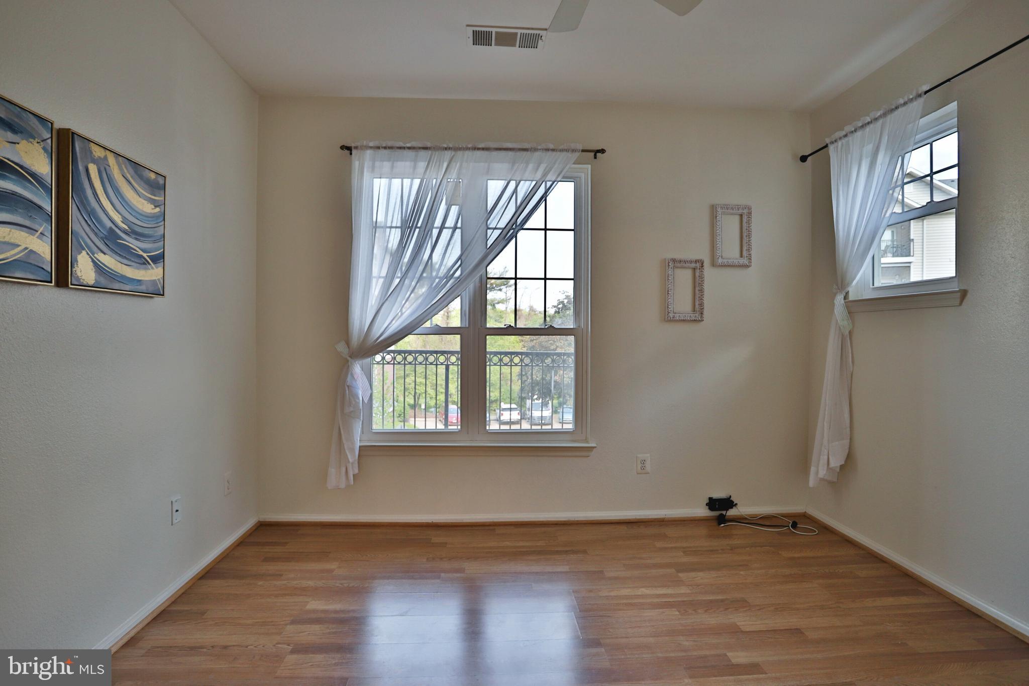 1570 Spring Gate Dr., Unit 7215 McLean, VA 22102 - Photo 10 of 30 an empty room with wooden floor and windows