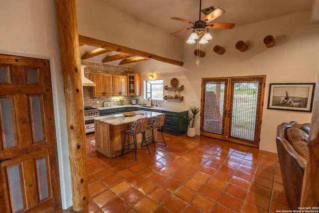 a kitchen with kitchen island granite countertop a sink stove and refrigerator