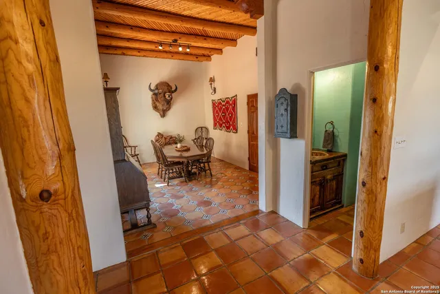 a bedroom with a bed a mirror on dresser and a wooden floor