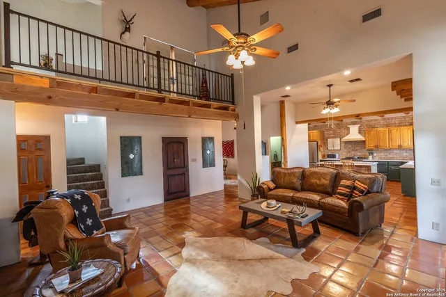 a kitchen with stainless steel appliances a sink a stove a refrigerator cabinets and dining table