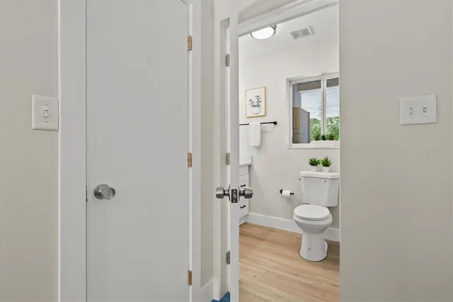 an empty room with wooden floor ceiling fan and windows