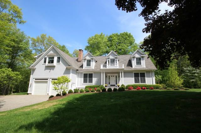 a front view of a house with a garden and trees