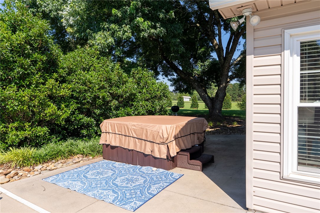 3513 Hopewell Road Anderson, SC 29621 - Photo 38 of 50 An inviting private spa awaits, nestled on a concrete patio bordered by natural landscaping.