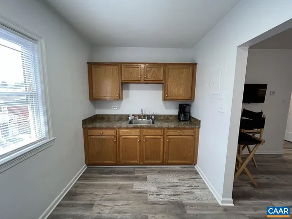 a view of kitchen with granite countertop cabinets stainless steel appliances and a window