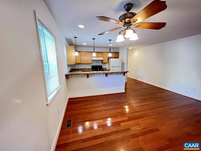 a view of kitchen with microwave a stove and white cabinets