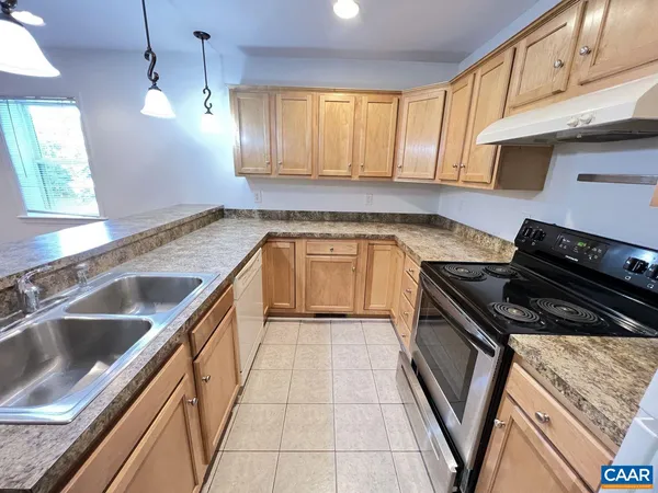 a kitchen with granite countertop stainless steel appliances a stove sink and cabinets