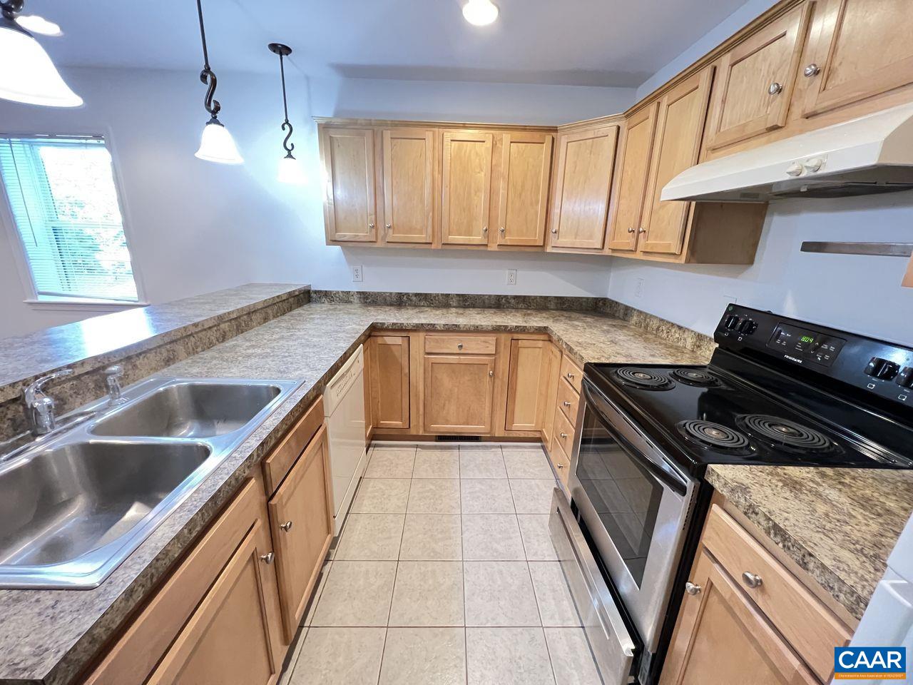 301 7th Street Southwest Charlottesville, VA 22903 - Photo 7 of 16 a kitchen with granite countertop stainless steel appliances a stove sink and cabinets