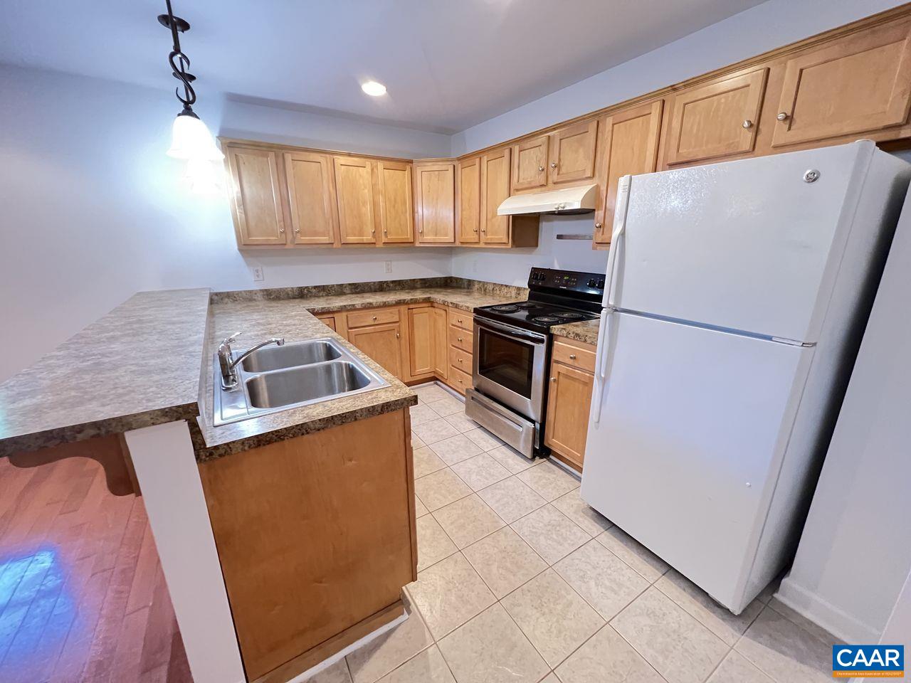 301 7th Street Southwest Charlottesville, VA 22903 - Photo 8 of 16 a kitchen with granite countertop a refrigerator a sink a stove a microwave and island