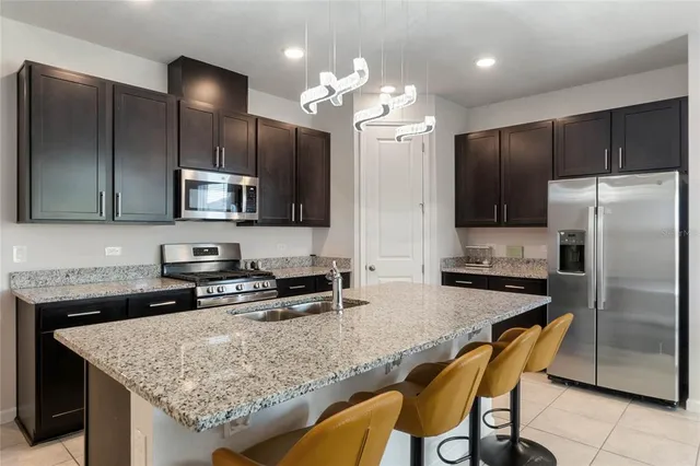 a kitchen with granite countertop kitchen island cabinets and stainless steel appliances
